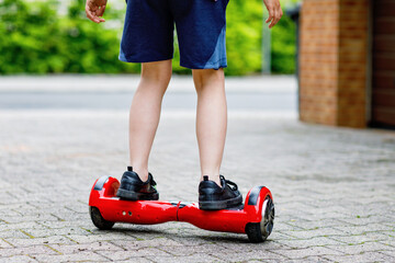 Close-up of kid boy on hover board. Child driving modern balance hoverboard. Excercise and sports...