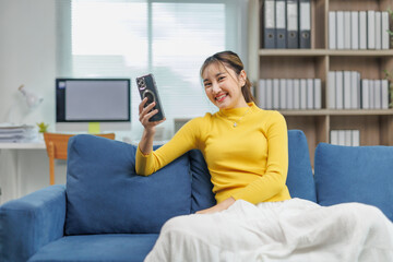 Happy asian freelancer woman using mobile phone for video call, working remotely from home and...