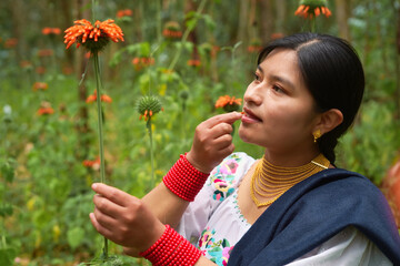 Indigenous woman smelling a flower in the field