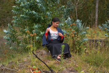 Indigenous otavalo woman wearing traditional clothes sitting in nature