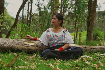 Indigenous woman wearing traditional clothes sitting in nature contemplating