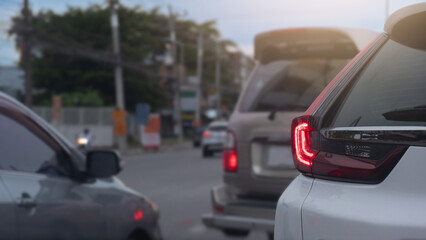 Rear side view of white car with turn on brake light. With other car prepar for U-Turn on the road. Beside of car with city and tree environment of moring time.