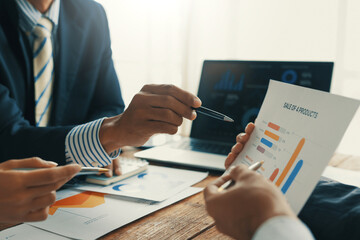 Business team discussing financial data and company growth shown on charts and graphs, analyzing...