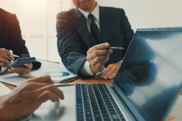 Business people using laptop and analyzing financial charts at meeting, discussing marketing...