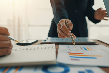 Businesswoman pointing financial chart explaining strategy to colleague during corporate meeting...