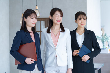 外を見つめる三人のスーツを着た女性