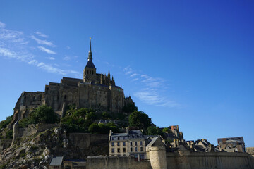 Obraz premium Mont Saint-Michel under a Vibrant Blue Sky, Normandy, France