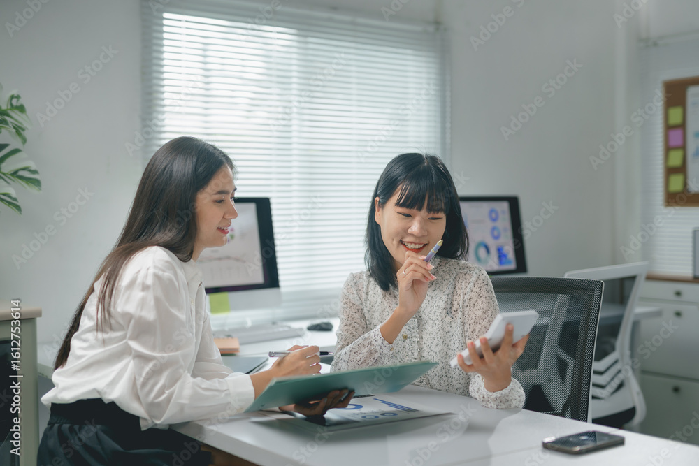 Aufkleber two joyful businesswomen collaborating and smiling while calculating profits, using a calculator and