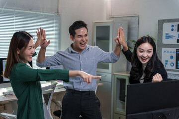 Euphoric businesspeople celebrating a successful project in a modern office, joyfully giving high fives while showcasing teamwork and unity in their vibrant corporate environment