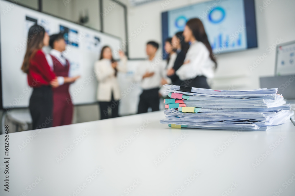 Poster stacked documents adorned with colorful sticky notes resting on a white table in an office meeting r