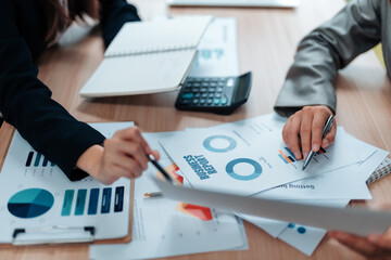 Business colleagues reviewing financial data, pointing at charts and graphs during a collaborative...