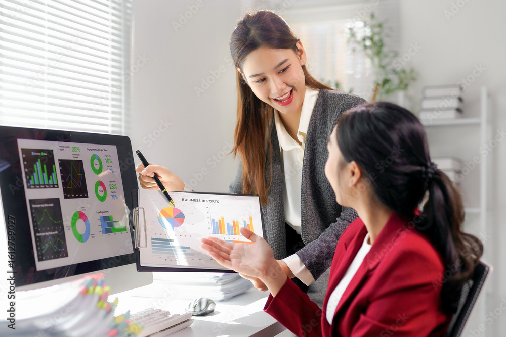 Aufkleber two asian businesswomen discussing marketing strategies in an office, analyzing reports and data on 