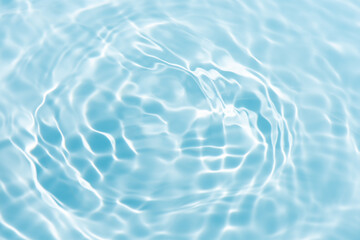 Blue water with ripples on the surface. Defocus blurred transparent blue colored clear calm water surface texture with splashes and bubbles. Water waves with shining pattern texture background.