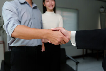 Two businesspeople shaking hands during a meeting in the office, sealing a deal or making an...