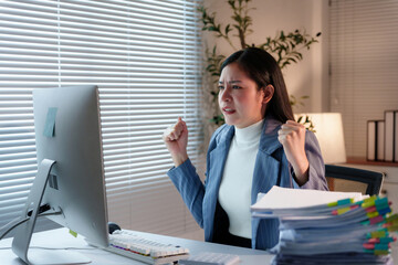 Young professional woman working in office is overwhelmed by workload and is showing frustration...