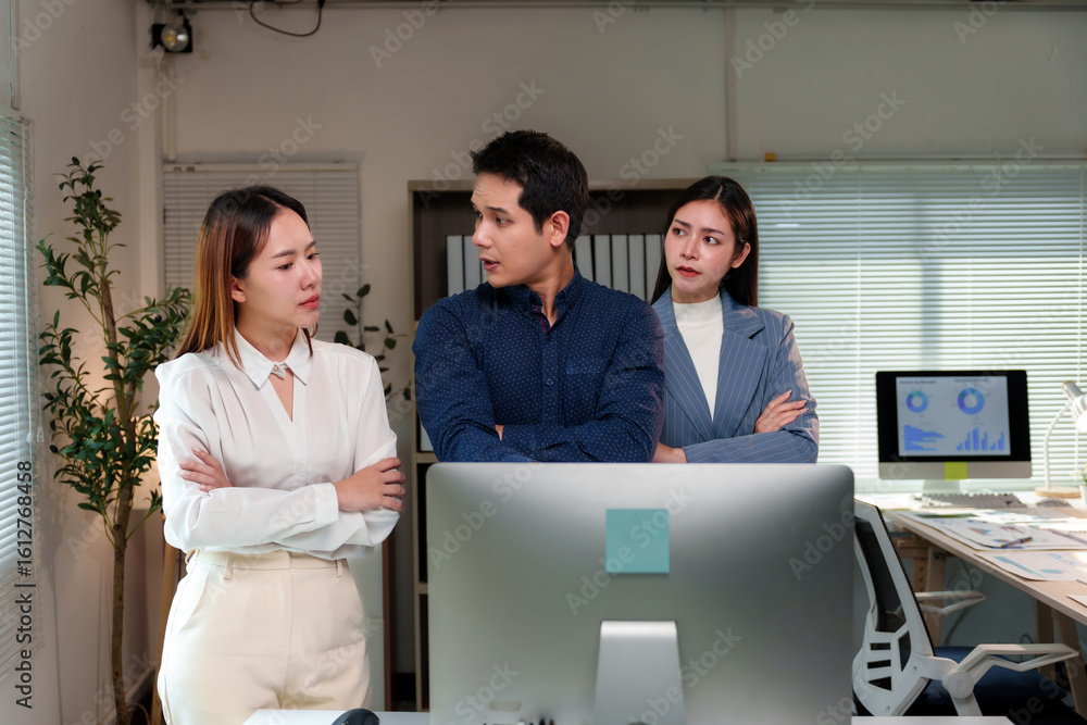 Poster three asian businesspeople are having a discussion with arms crossed in front of a computer in a mod