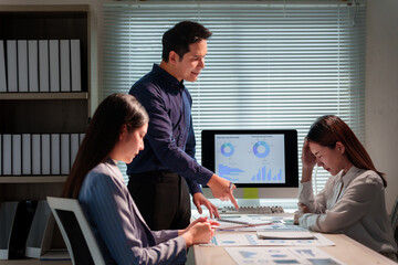 Asian businesspeople working together in modern office. Male manager pointing at financial report...