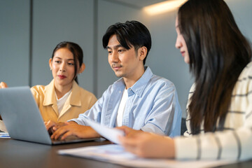 Obraz premium Asian business team brainstorming together, strategic planning with tablet in office, inclusive workplace, financial strategy, b2b startup innovation, teamwork seminar and corporate collaboration