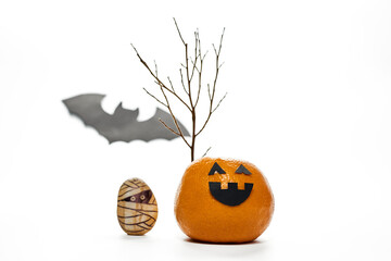 Creative Halloween characters made from an orange and a stone, isolated on white.