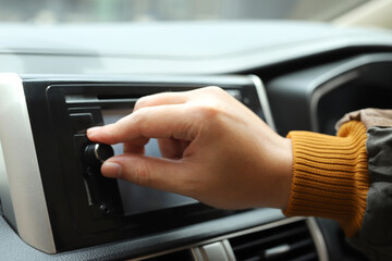 Turn on the radio in the car.
