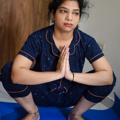 Young Indian woman practicing yoga indoor by online yoga session, Beautiful girl practice basic yoga pose, Asian Indian lady doing indoor yoga