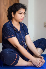 Young Indian woman practicing yoga indoor by online yoga session, Beautiful girl practice basic yoga pose, Asian Indian lady doing indoor yoga