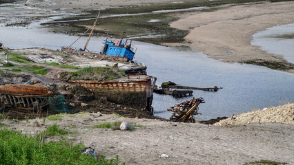 old abandoned sunken ship in the water at the ship cemetery