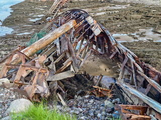 old abandoned sunken ship in the water at the ship cemetery