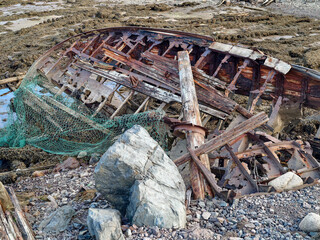 old abandoned sunken ship in the water at the ship cemetery