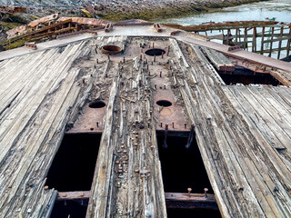 old abandoned sunken ship in the water at the ship cemetery wood pattern