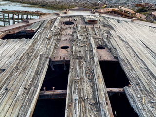 old abandoned sunken ship in the water at the ship cemetery wood pattern