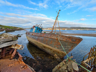 old abandoned sunken ship in the water at the ship cemetery wood pattern