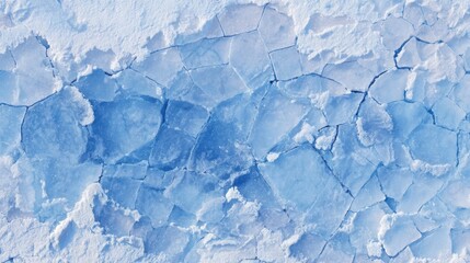 Ice covers a lake surface with unique, cracked patterns reflecting various shades of blue. The scene captures the stillness and beauty of winter's frozen landscapes.