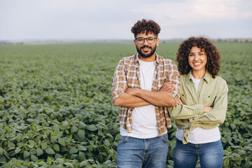 Interracial team of agronomists posing in soybean field