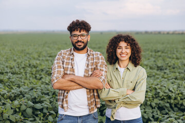 Interracial team of agronomists posing in soybean field