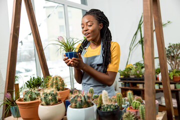 Flower shop assistant cutting flowers and looking contented and happy