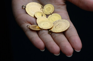 Hand holding gold coins, close up