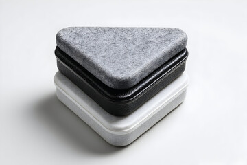 Modern geometric storage boxes made from felt and leather displayed on a minimalist surface in a bright indoor setting