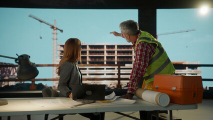 Construction engineer explaining building project to architect using virtual reality software