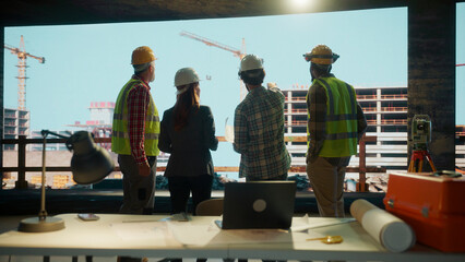 Construction workers and architect reviewing building plans on site