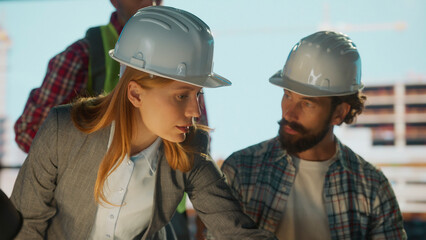 Engineers and architects discussing blueprint on construction site