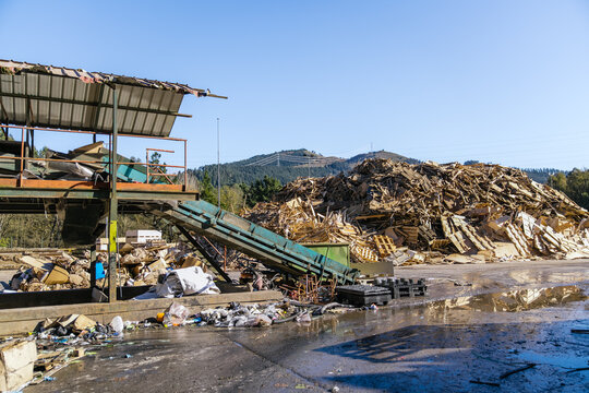Industrial waste sorting conveyor belt processing wood scraps at a recycling facility, promoting environmental sustainability and resource management