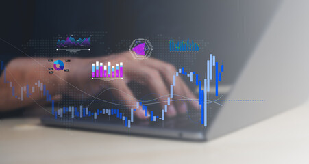 A close-up of hands typing on a laptop with overlaid dynamic financial charts and graphs indicating...