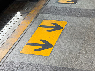 Close up of Yellow directional arrows painted on the platform floor at BTS Skytrain station in...