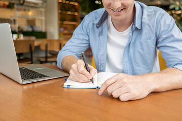 Ginger young man sitting at the table in the cafe