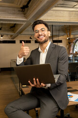 Young good-looking young manager feeling positive while working in the office