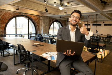 Young good-looking young manager feeling positive while working in the office