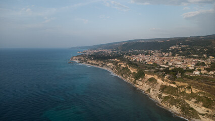 Naklejka premium Coastal Town with Cliffside Architecture and Turquoise Sea – Aerial View, Southern Italy