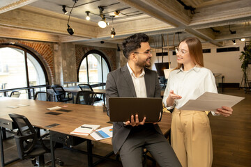 Colleagues in the office discussing project details and looking involved