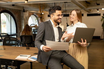 Colleagues discussing something and looking joyful and excited